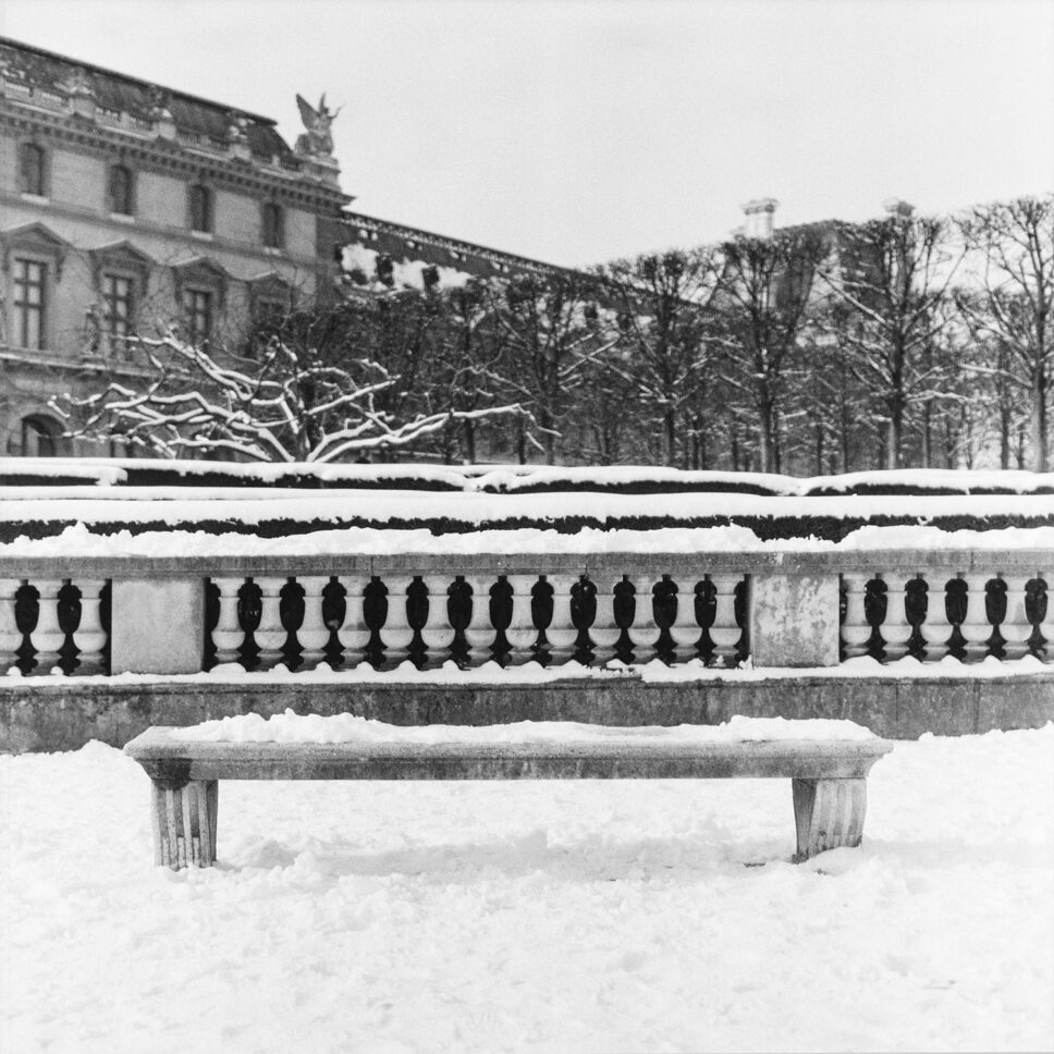 Banco de piedra vacío y nevado en las Tullerías frente al Louvre, fotografía en película en blanco y negro de formato medio.