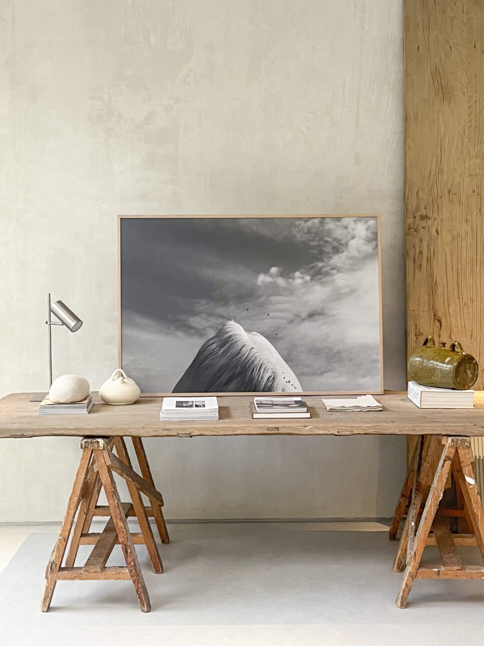 Black-and-white horse photograph from BERNI by Emilia Brandão Carneiro, displayed on a wooden table at Lorna de Santos’s Madrid studio